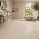 Vloertegel steenlook Vida Arena 100 x 100 cm in badkamer met vrijstaand bad en olijfboom – sfeerfoto