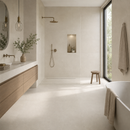 Vloertegel steenlook Vida Arena 100 x 100 cm in badkamer met messing kranen en inloopdouche – sfeerfoto